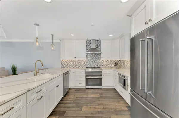 a kitchen with granite countertop a table chairs stove a sink and a refrigerator