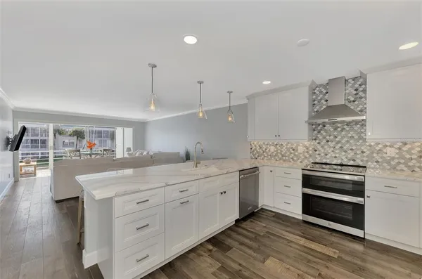 a kitchen with kitchen island a dining table chairs sink and cabinets