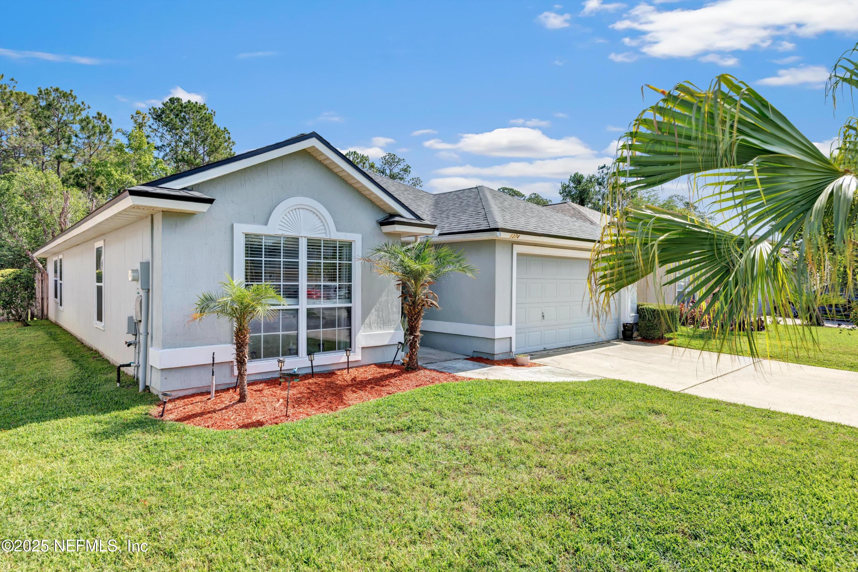 a front view of a house with a garden and yard