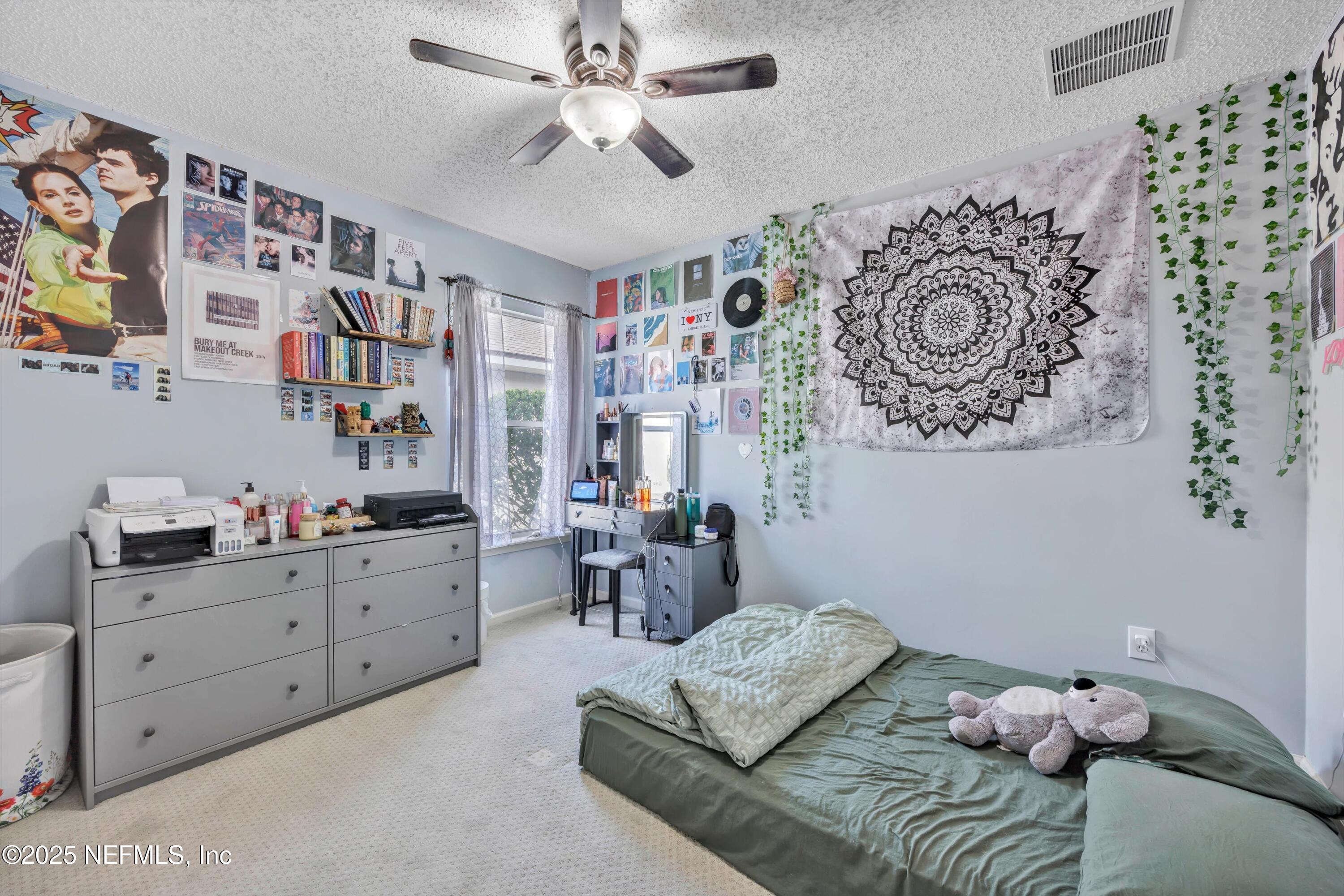 1374 Brookgreen Way Fleming Island, FL 32003 - Photo 12 of 21 a bedroom with a bed and a chandelier