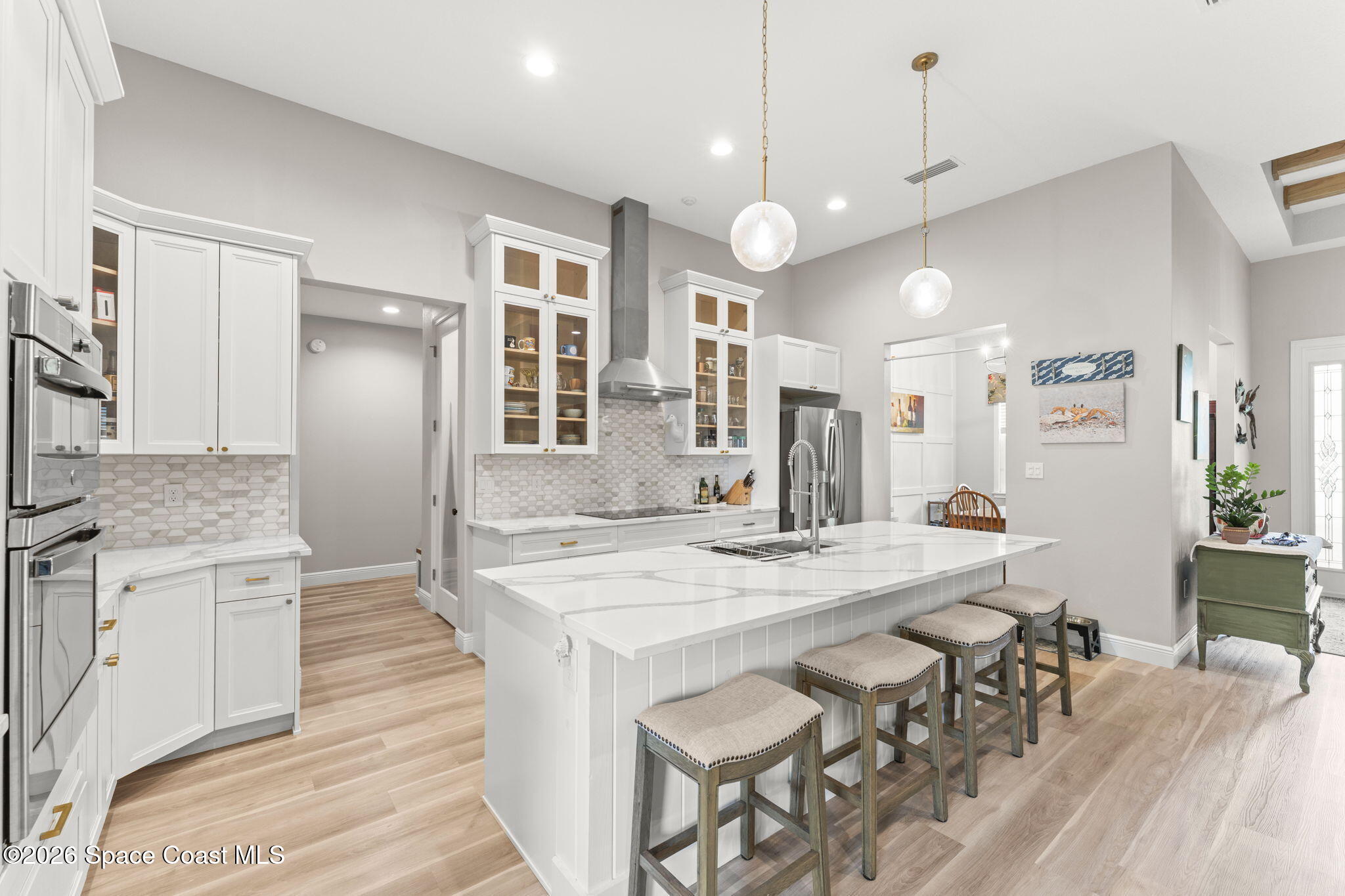 1740 Ford Road Mims, FL 32754 - Photo 17 of 43 a kitchen with stainless steel appliances kitchen island granite countertop a refrigerator a stove and a dining table with wooden floor