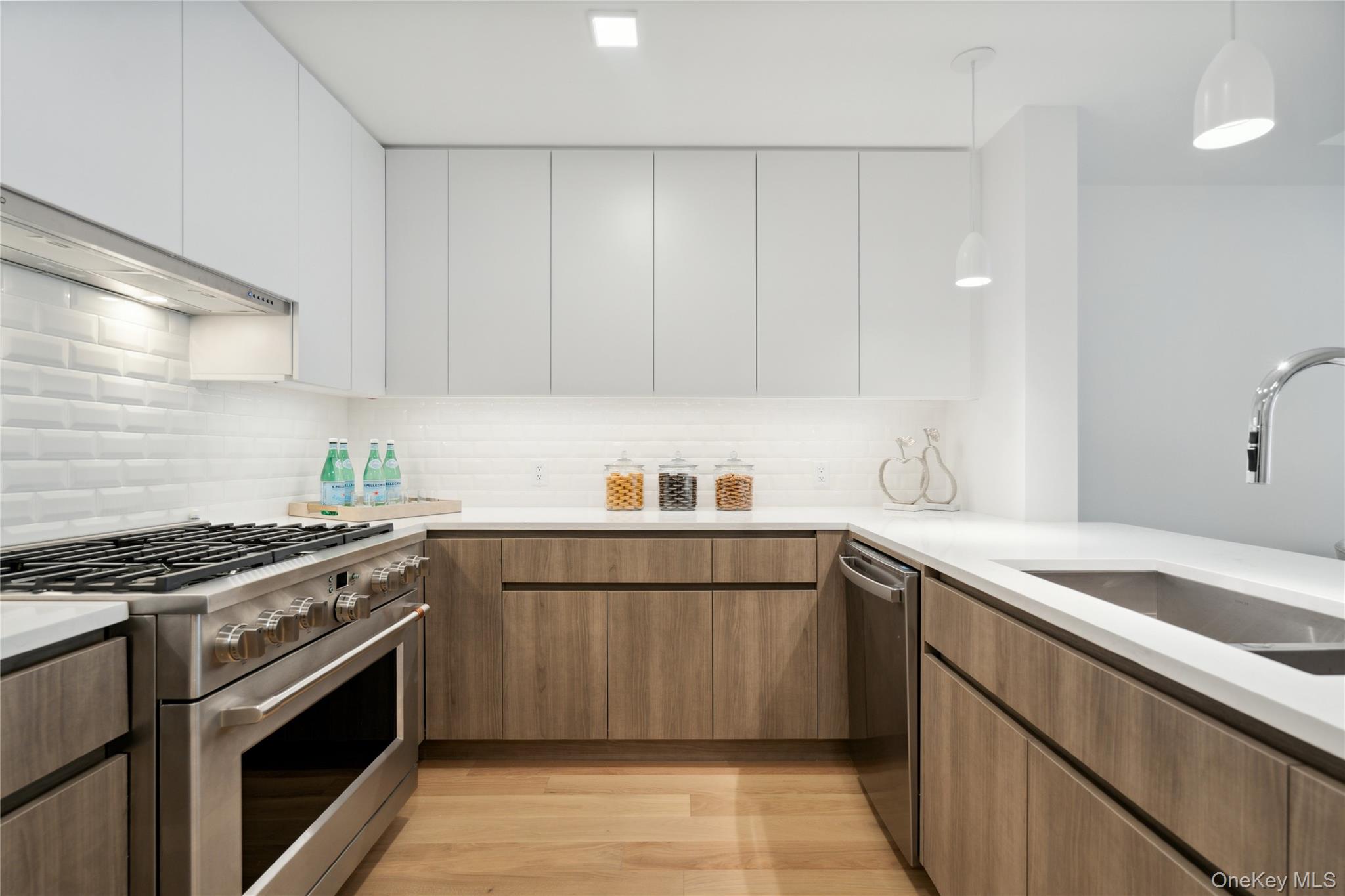 218 Middle Neck Road, Unit 302 Great Neck, NY 11021 - Photo 25 of 30 Kitchen with white cabinetry, sink, hanging light fixtures, and appliances with stainless steel finishes