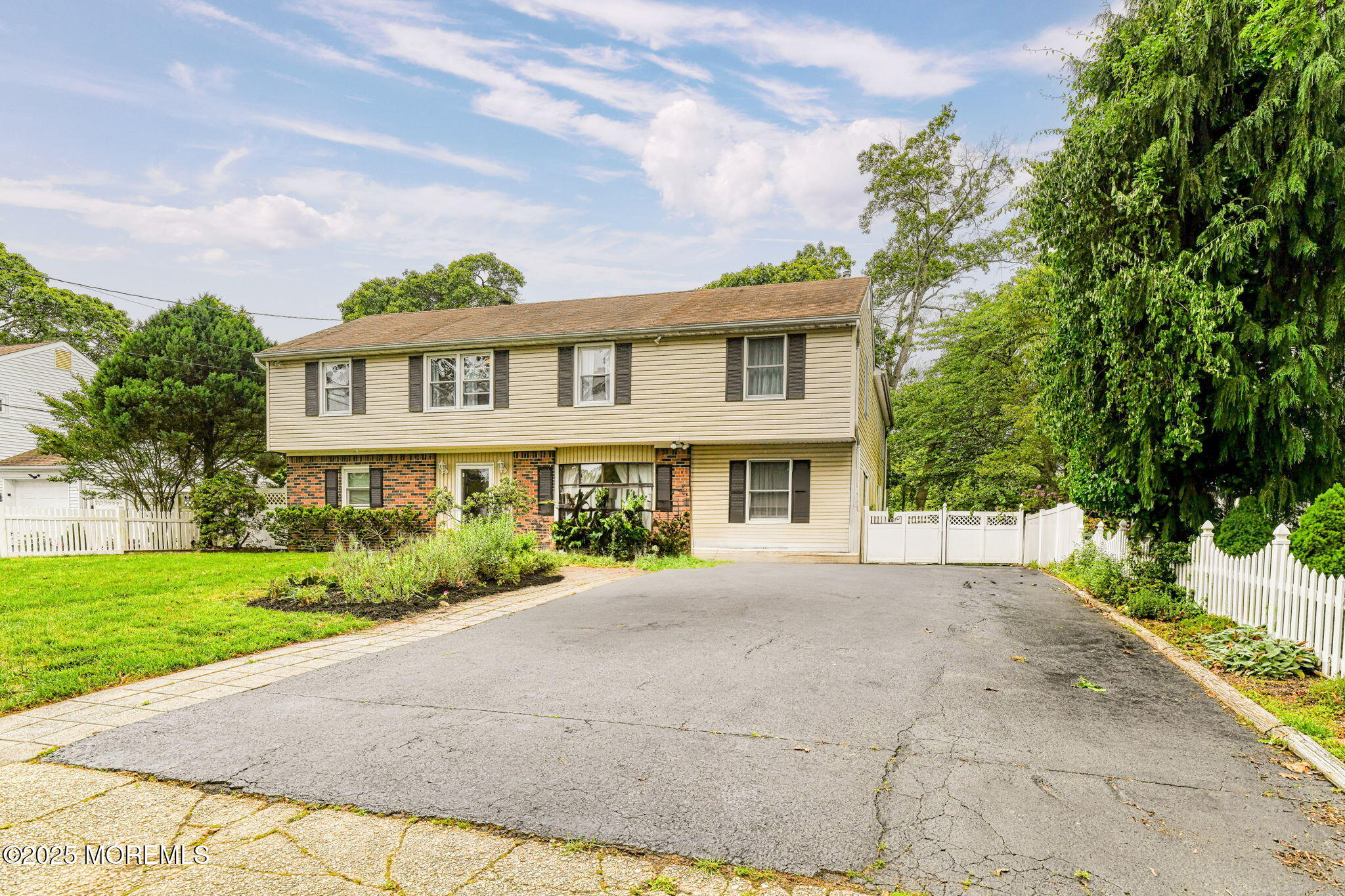 24 Peach Tree Road Oakhurst, NJ 07755 - Photo 2 of 34 a front view of a house with a yard and potted plants