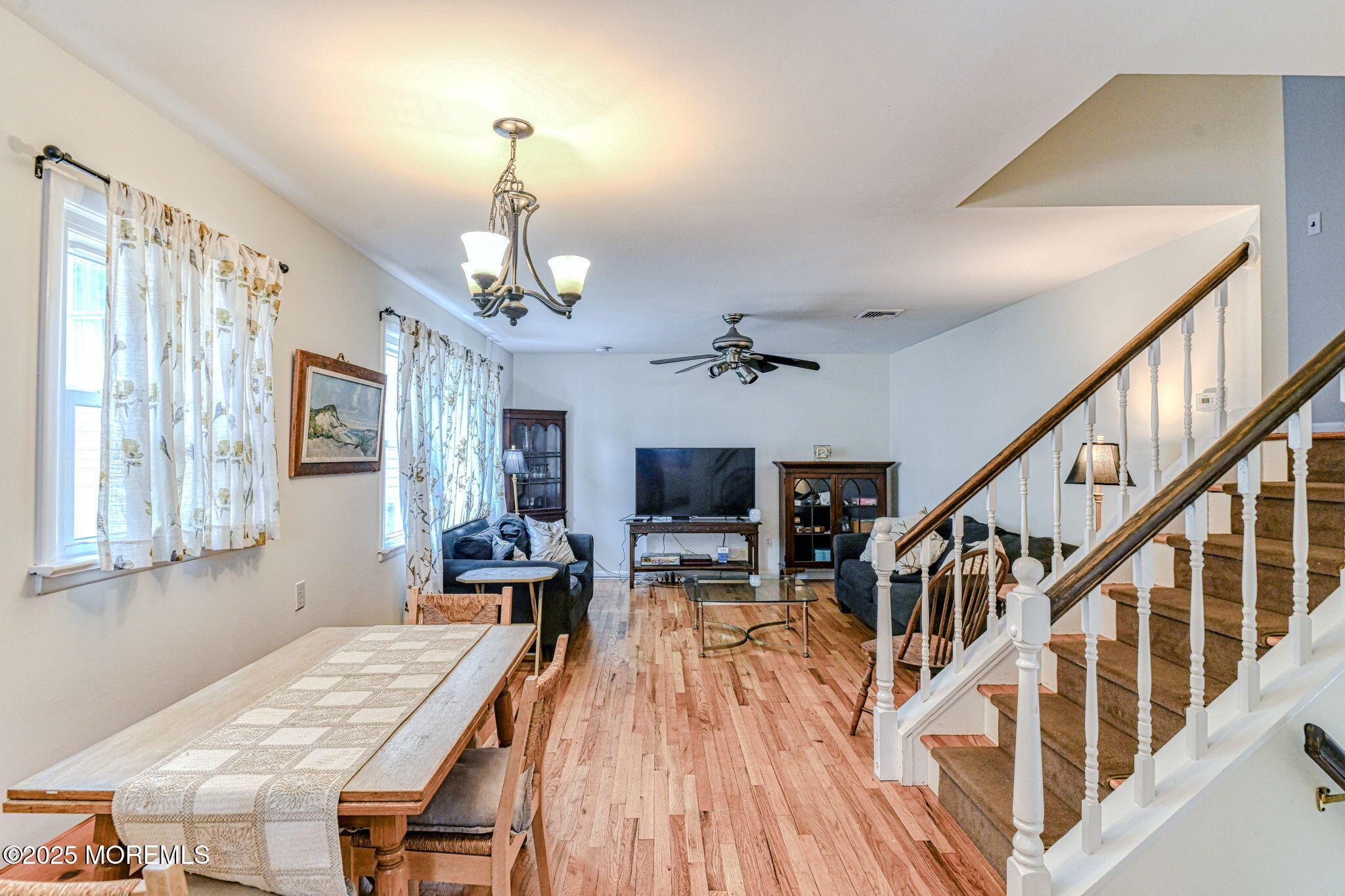 24 Peach Tree Road Oakhurst, NJ 07755 - Photo 27 of 34 a dining room with wooden floor a chandelier a wooden table and chairs