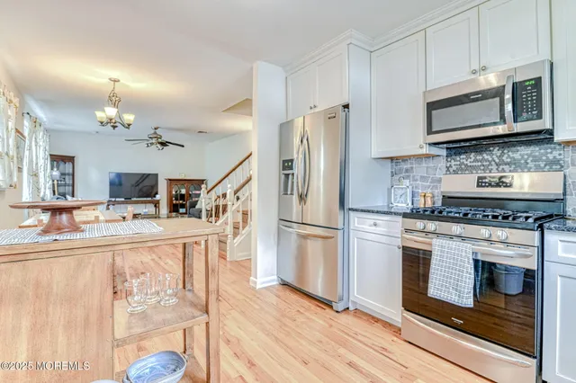a kitchen with granite countertop a refrigerator stove and microwave