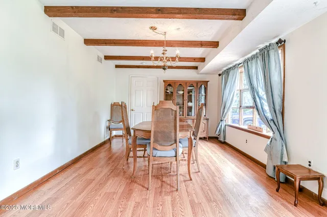 a dining room with wooden floors and a rug