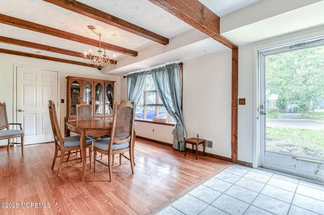 a dining room with wooden floor a glass table and windows