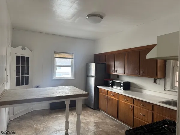 a kitchen with refrigerator cabinets and wooden floor