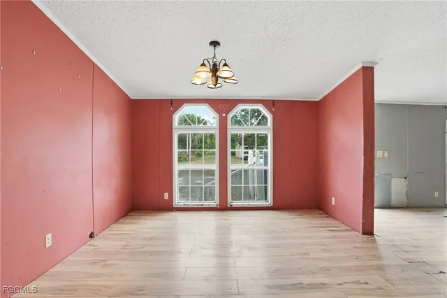 a view of an empty room with a window and bathroom