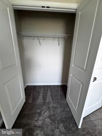a view of a hallway with wooden floor and seating space