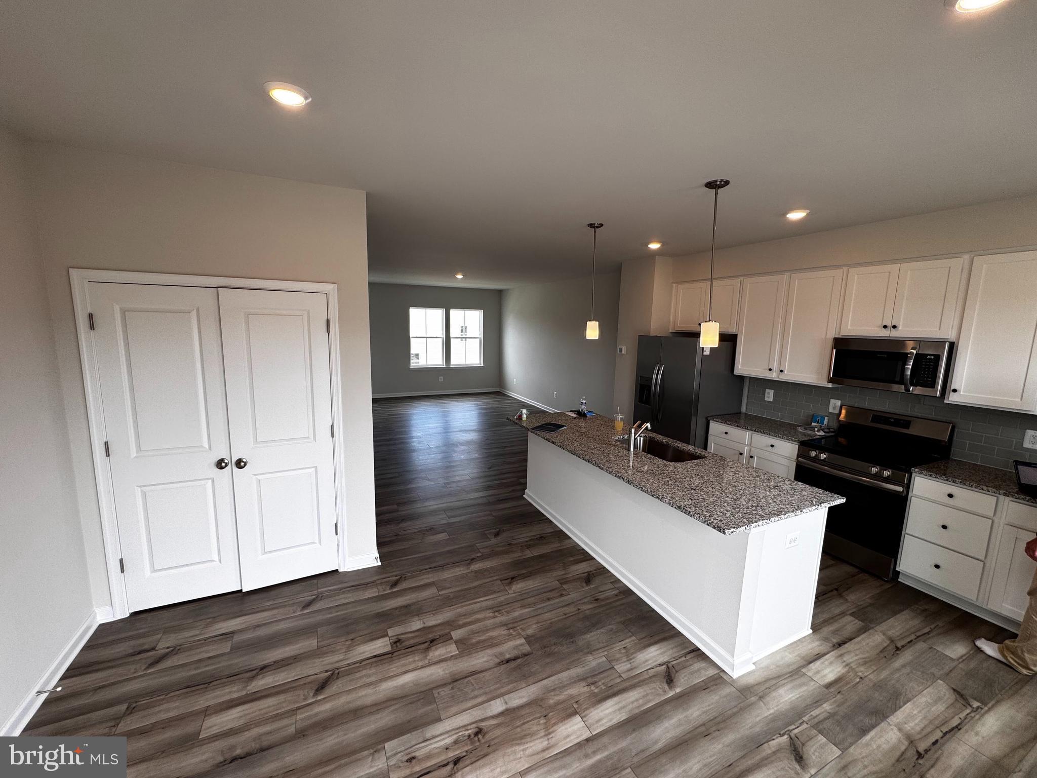 1258 Red Clover Lane Ranson, WV 25438 - Photo 10 of 25 a large white kitchen with wooden floor and a sink
