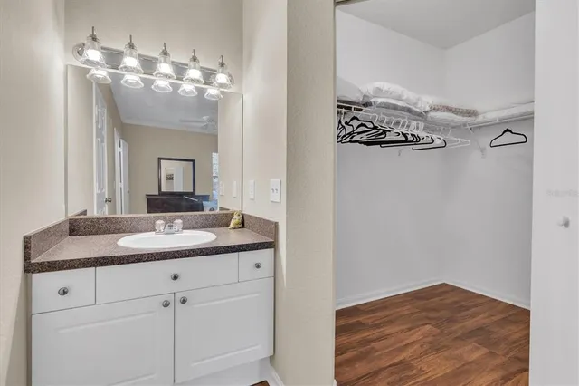 a en suite bathroom with a granite countertop sink and a mirror