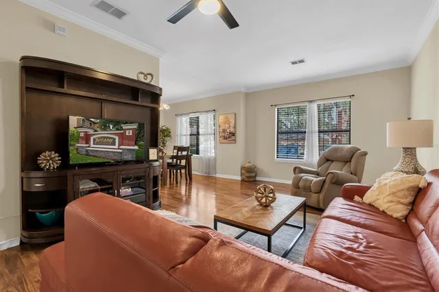 a living room with furniture a large window and a flat screen tv