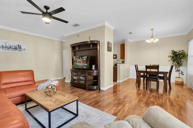 a living room with furniture a dining table and chairs with wooden floor