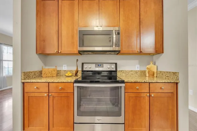 a kitchen with stainless steel appliances granite countertop a stove a sink and a microwave