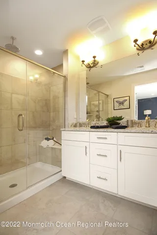 a bathroom with a granite countertop sink a mirror and a shower