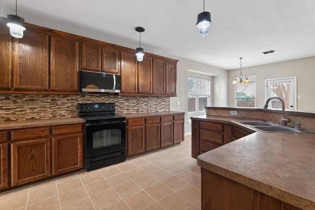 a kitchen with stainless steel appliances a stove sink microwave and cabinets