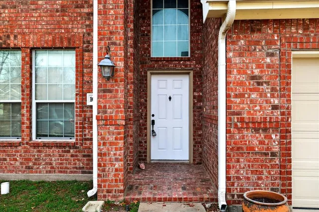 a view of a brick house with a door and a yard