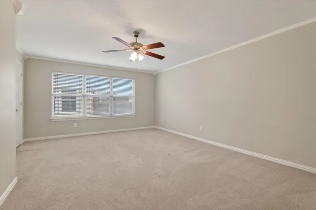 a view of an empty room with a ceiling fan and window