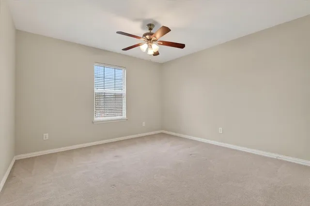 a view of an empty room with a ceiling fan