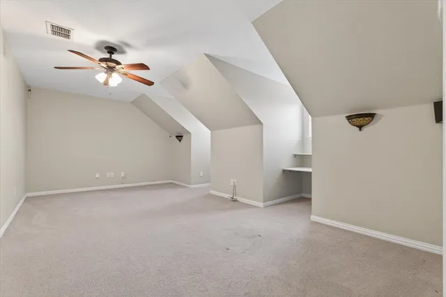 an empty room with ceiling fan and window