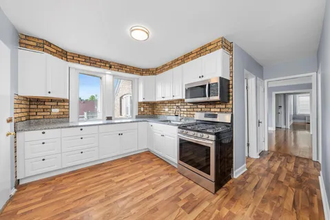 a kitchen with granite countertop a stove top oven and cabinets