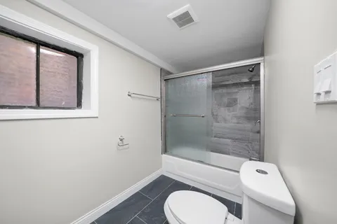 a bathroom with a toilet a sink and shower
