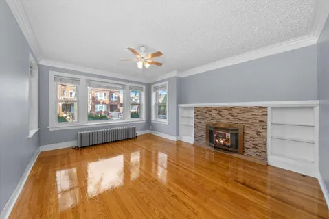 wooden floor fireplace and windows in an empty room