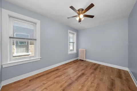 a view of a big room with wooden floor and windows