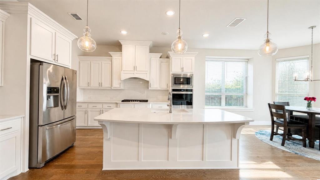912 Fallbrook Avenue Denton, TX 76210 - Photo 5 of 26 a large kitchen with kitchen island a large counter top space and stainless steel appliances