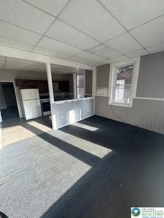 a view of an empty room with window and fireplace