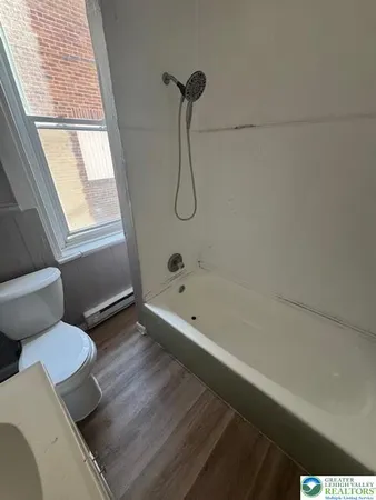 a bathroom with a granite countertop toilet a sink and bathtub