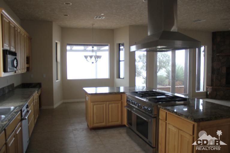 53966 Ridge Road Yucca Valley, CA 92284 - Photo 5 of 20 a kitchen with stainless steel appliances granite countertop a stove a sink and a microwave