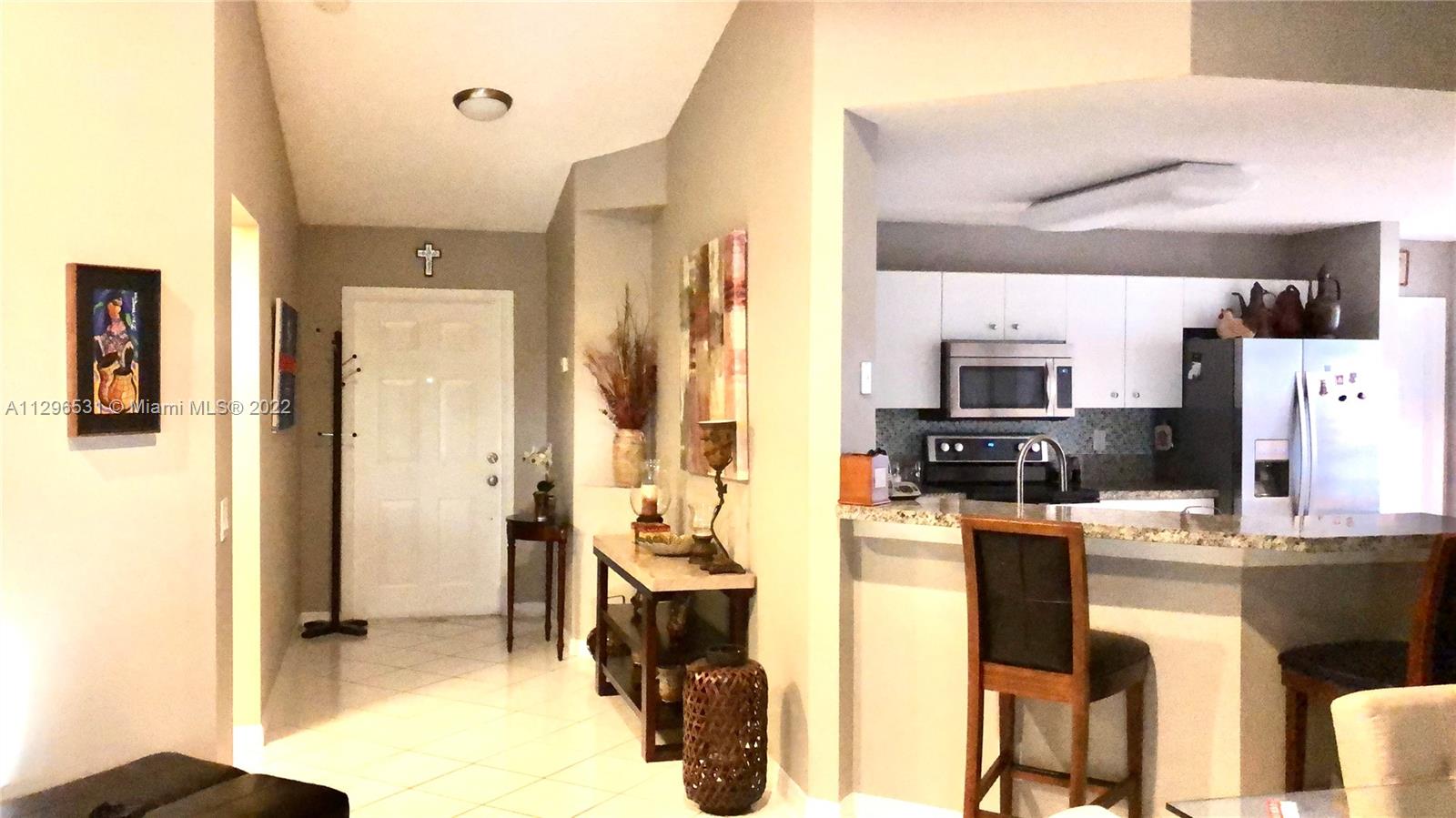 Savanna Weston, FL 33327 - Photo 2 of 7 a living room with stainless steel appliances kitchen island granite countertop furniture and a view of kitchen