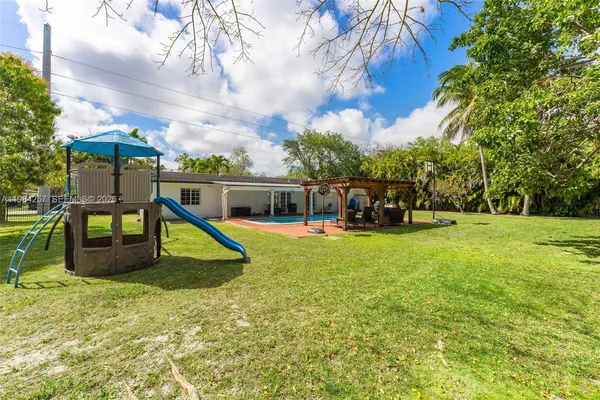 a view of a swimming pool with a bench and trees