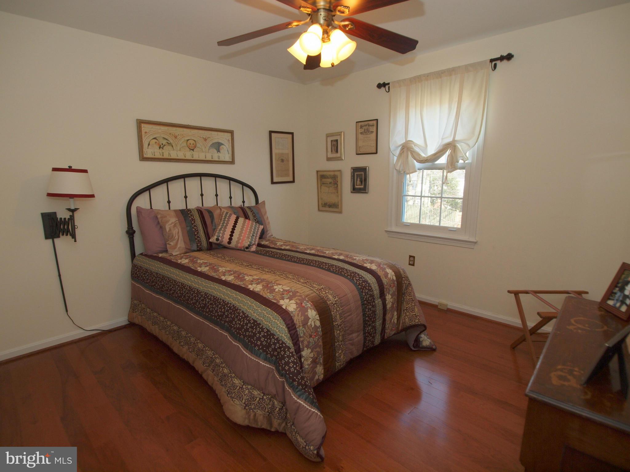 6823 Spring Beauty Court Springfield, VA 22152 - Photo 16 of 29 a bedroom with a bed and a chandelier