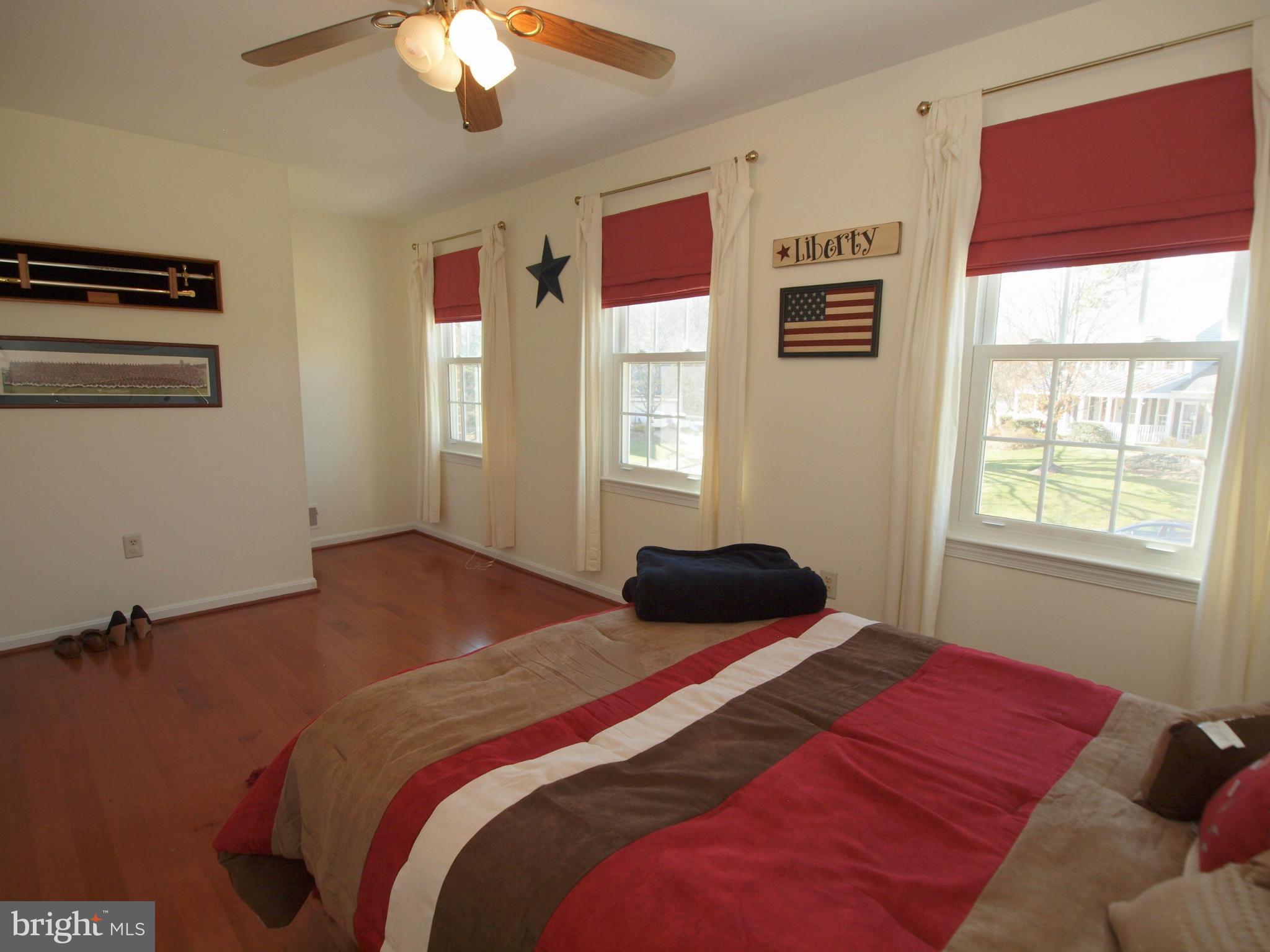 6823 Spring Beauty Court Springfield, VA 22152 - Photo 18 of 29 a bedroom with a bed and a chandelier