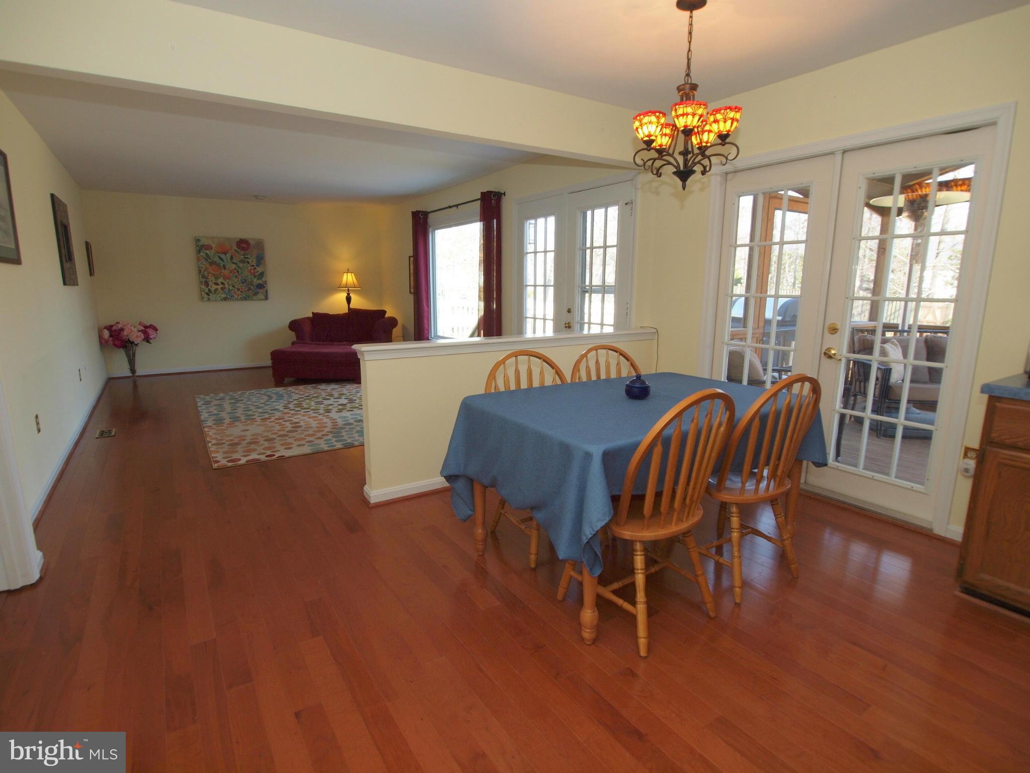 6823 Spring Beauty Court Springfield, VA 22152 - Photo 8 of 29 a living room with furniture dining table wooden floor and a chandelier