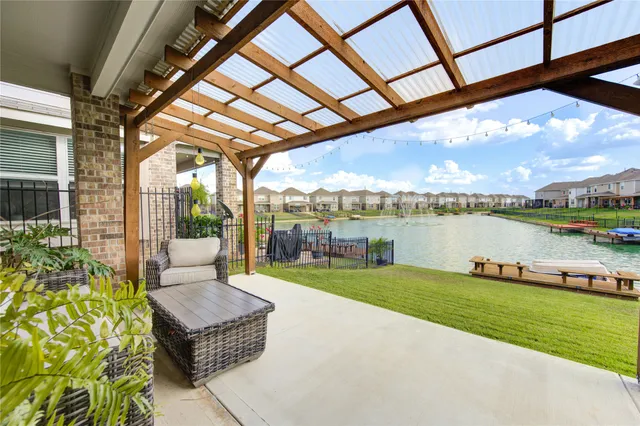 a patio with water view and a backyard