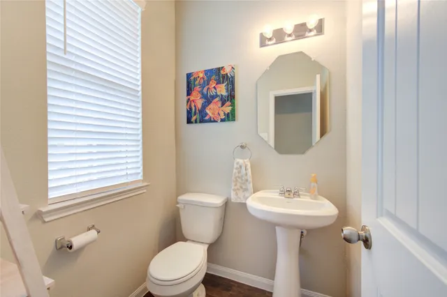 a bathroom with a toilet sink and mirror