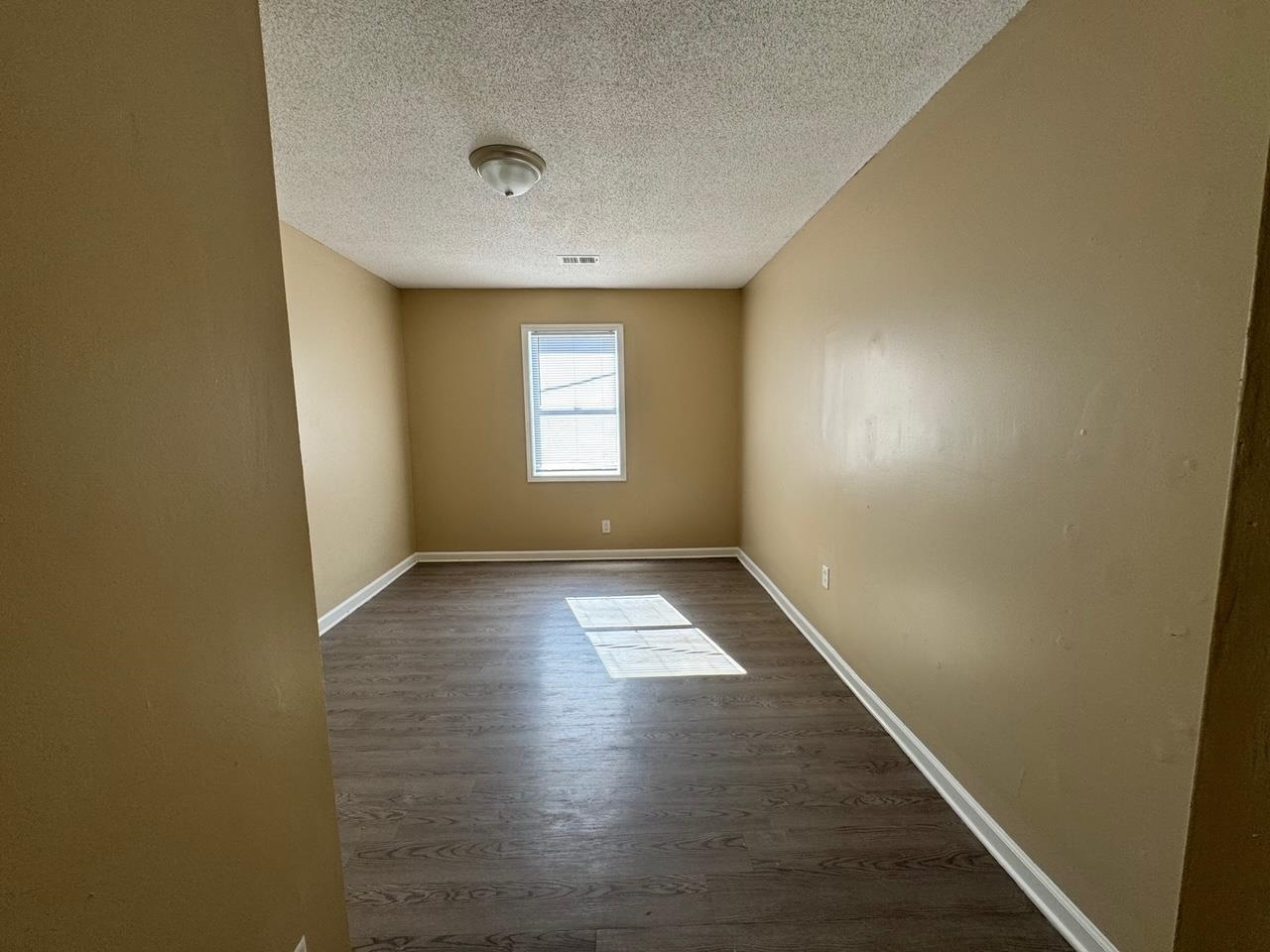 243 West Brooks Road Memphis, TN 38109 - Photo 11 of 19 an empty room with wooden floor and windows