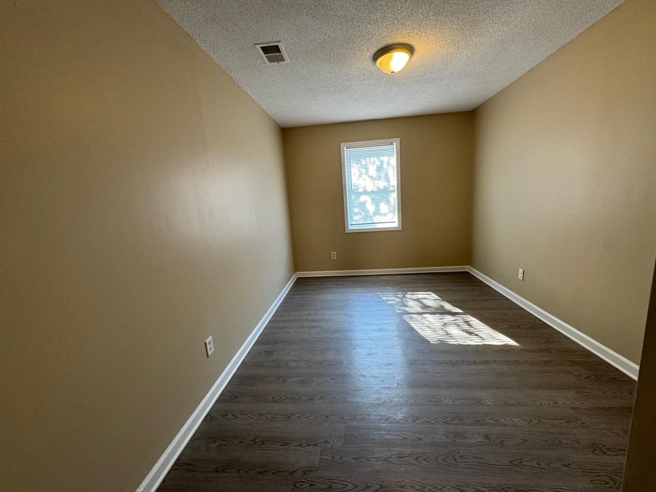 243 West Brooks Road Memphis, TN 38109 - Photo 14 of 19 an empty room with wooden floor and windows