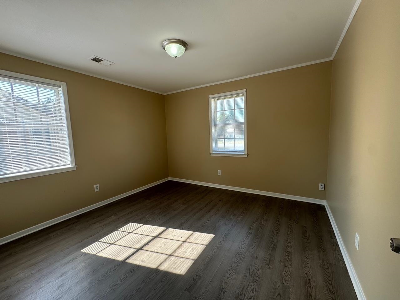 243 West Brooks Road Memphis, TN 38109 - Photo 18 of 19 an empty room with wooden floor and windows