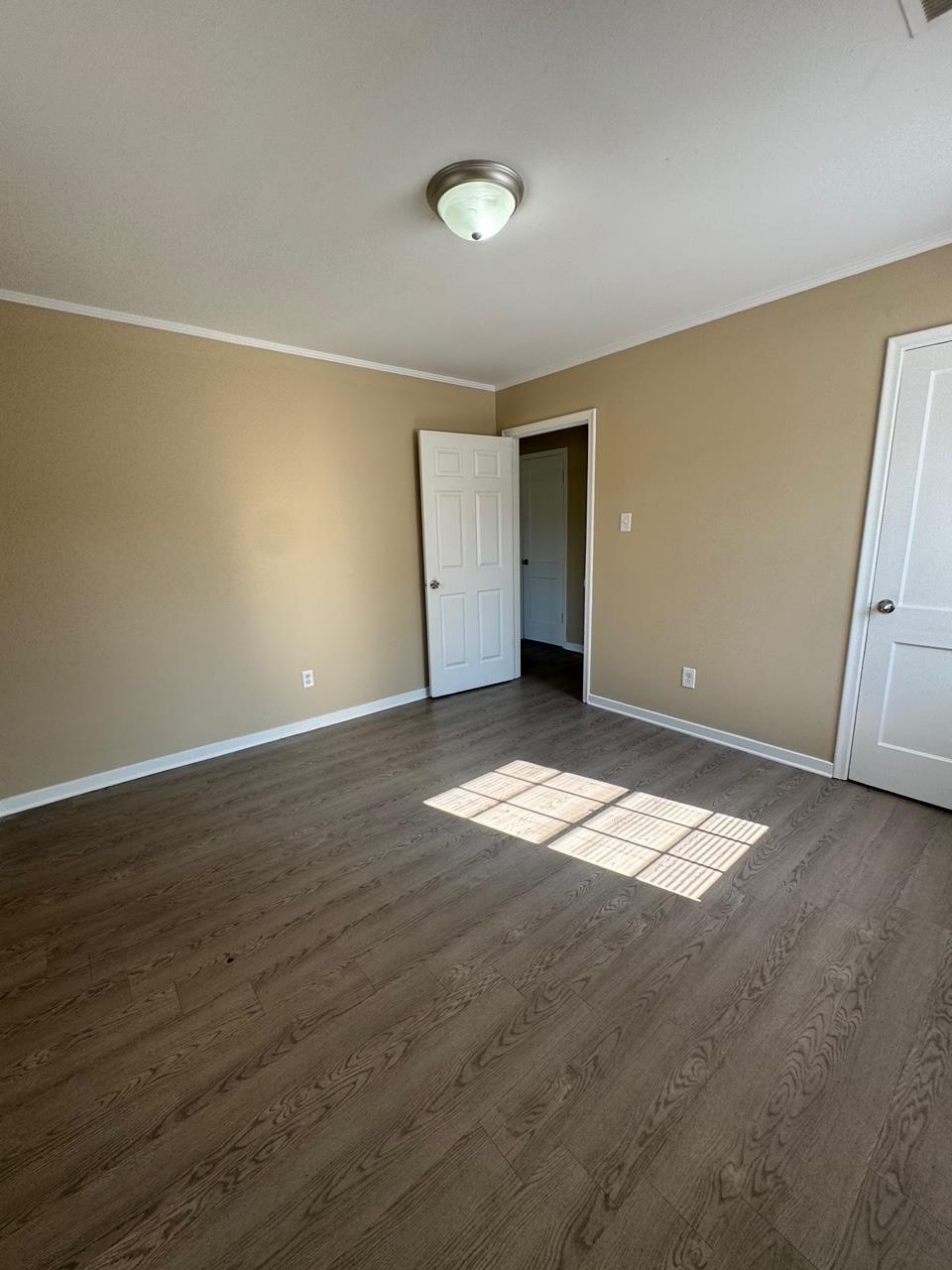 243 West Brooks Road Memphis, TN 38109 - Photo 19 of 19 an empty room with wooden floor and windows