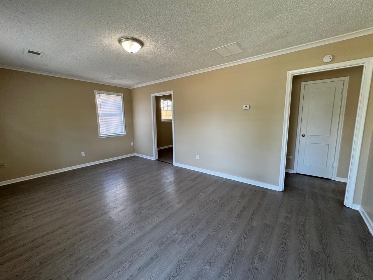243 West Brooks Road Memphis, TN 38109 - Photo 6 of 19 a view of an empty room with wooden floor and a window