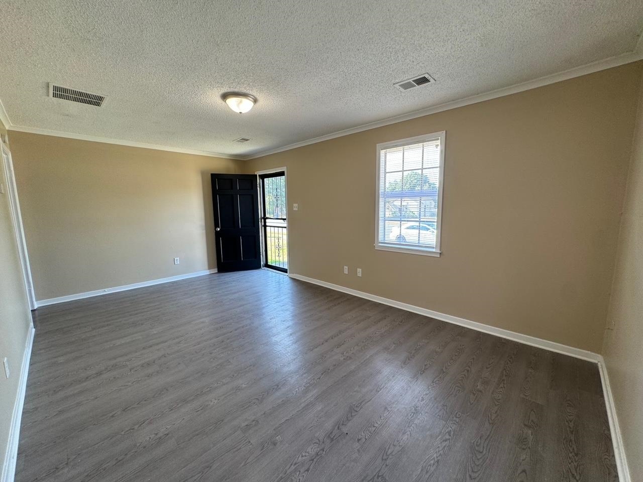 243 West Brooks Road Memphis, TN 38109 - Photo 7 of 19 a view of an empty room with wooden floor and window