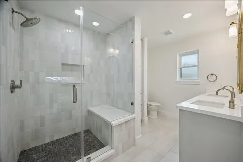 a bathroom with a sink a toilet and shower