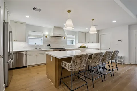 a kitchen with a table chairs microwave and cabinets