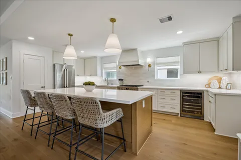 a kitchen with kitchen island granite countertop a sink counter and chairs