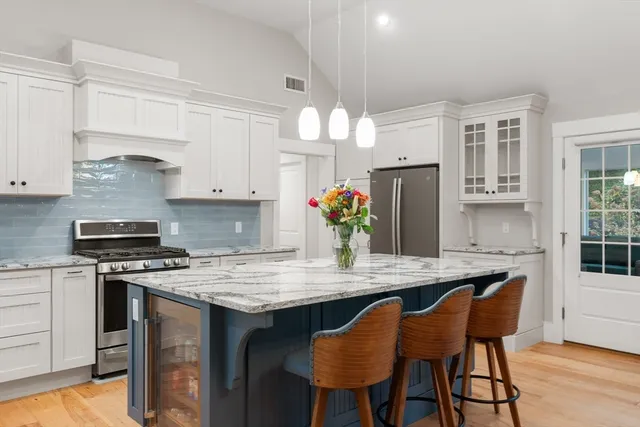 a kitchen with granite countertop a table chairs stove and cabinets